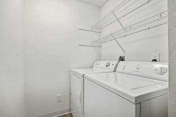 A white laundry room with a washer and dryer.